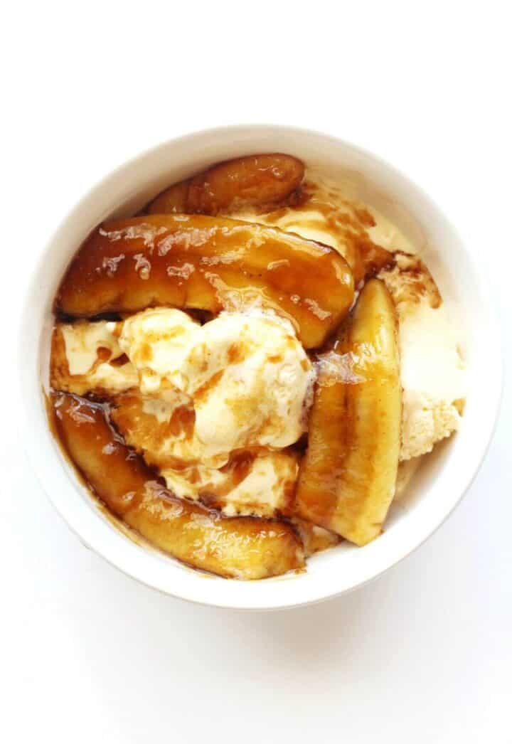 Bananas fosters in a bowl with vanilla ice cream.