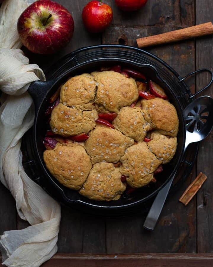 A plum and apple cobbler in a cast iron pan.