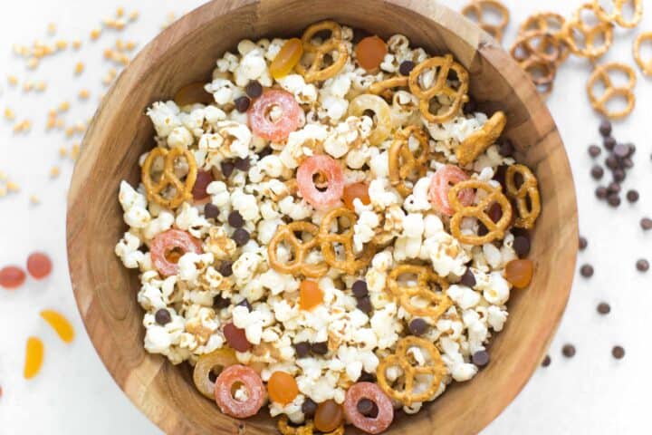 Popcorn, pretzels and candy in a wooden bowl.