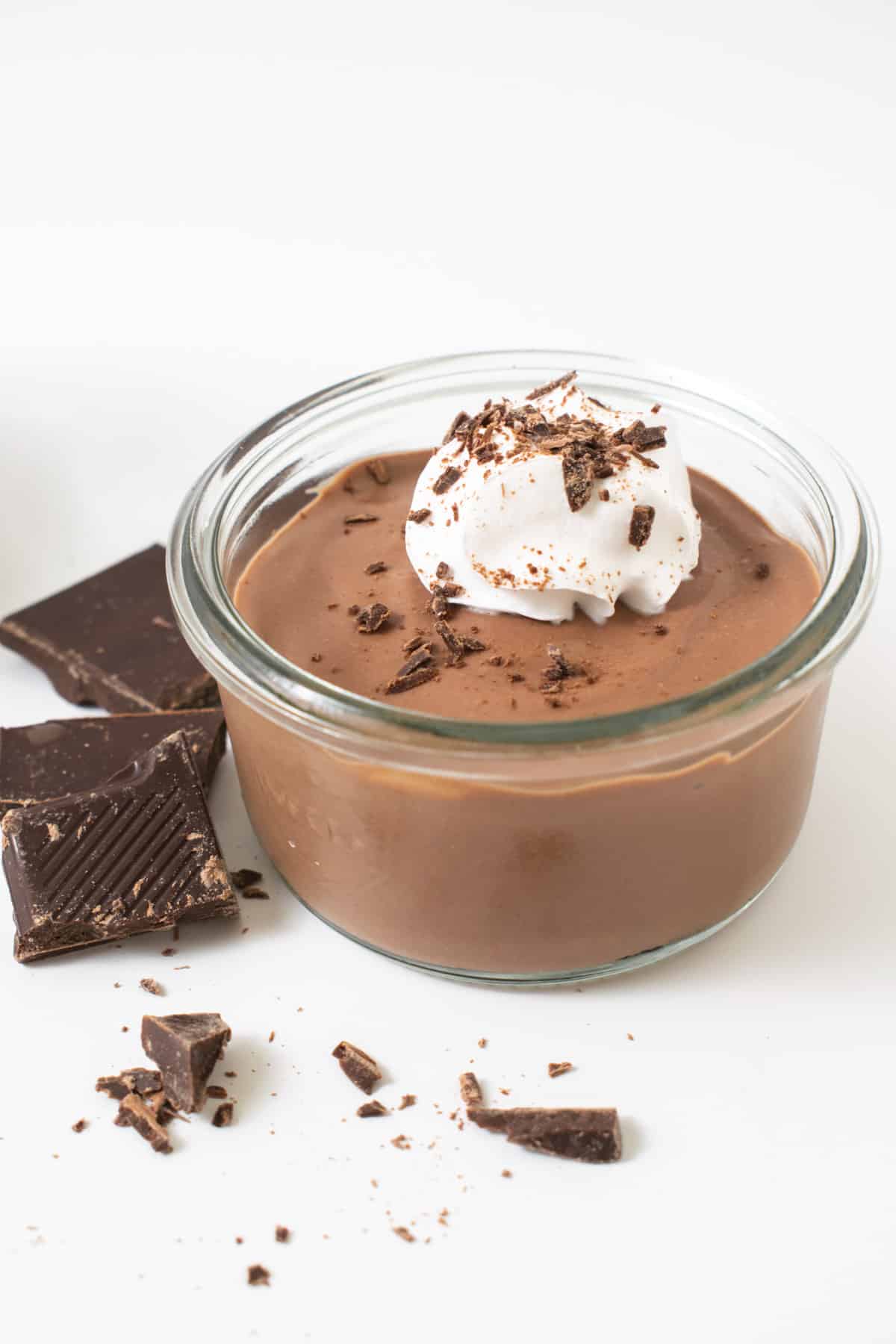 A portion of mousse topped with vegan crean and dark chocolate.