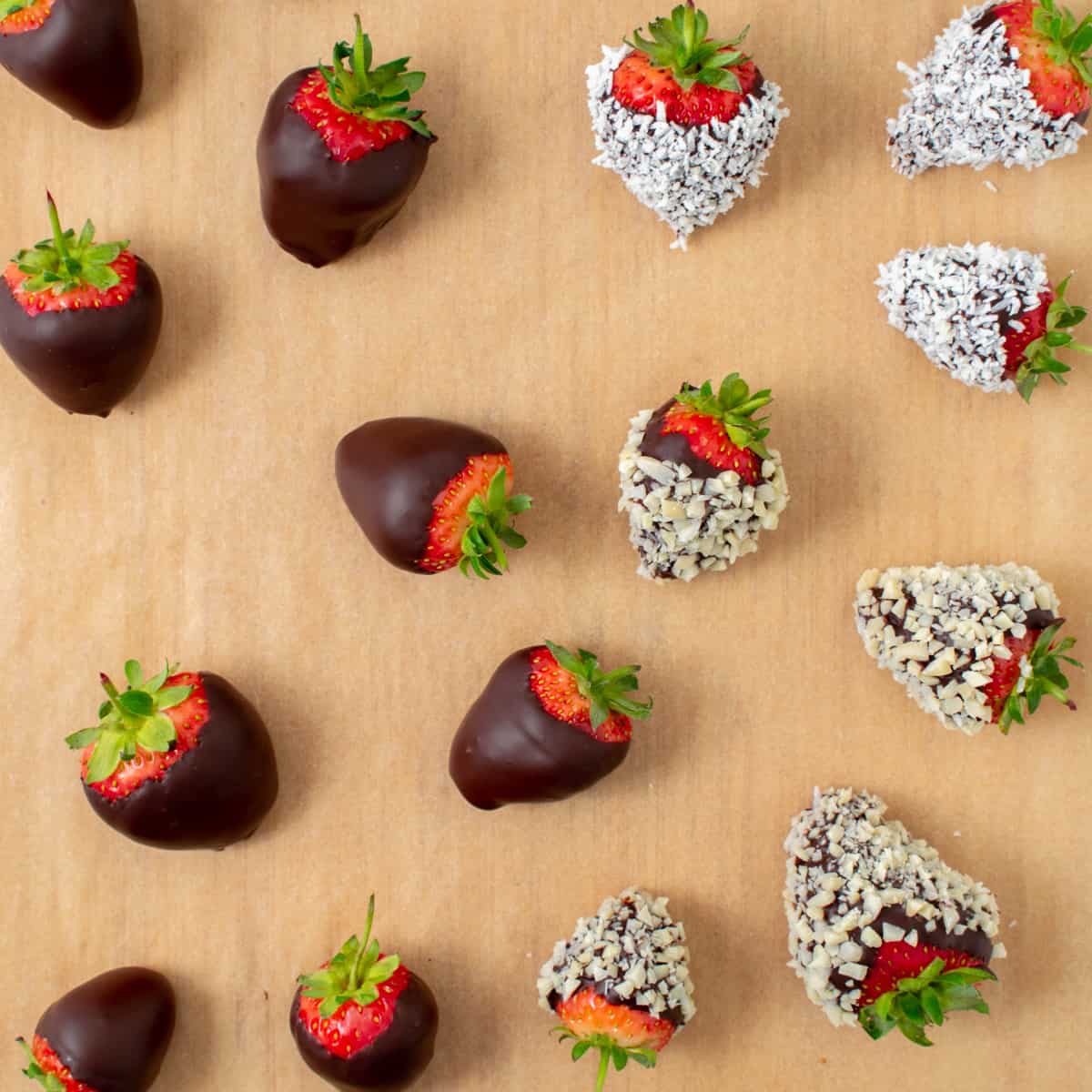 Chocolate covered strawberries setting on parchment paper.