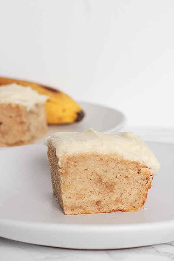 A square slice of banana cake on a plate.