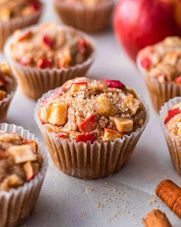 Muffins with apple pieces and sugar on top.