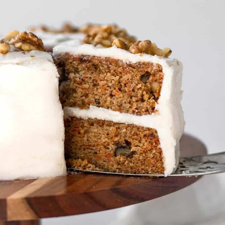 Removing a slice of carrot cake from the whole cake.
