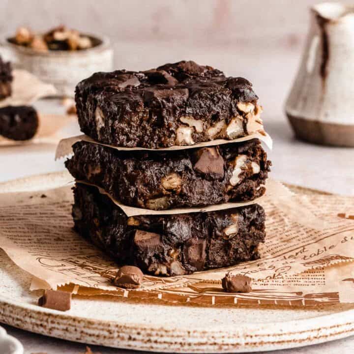 Three fudgy brownies in a stack.