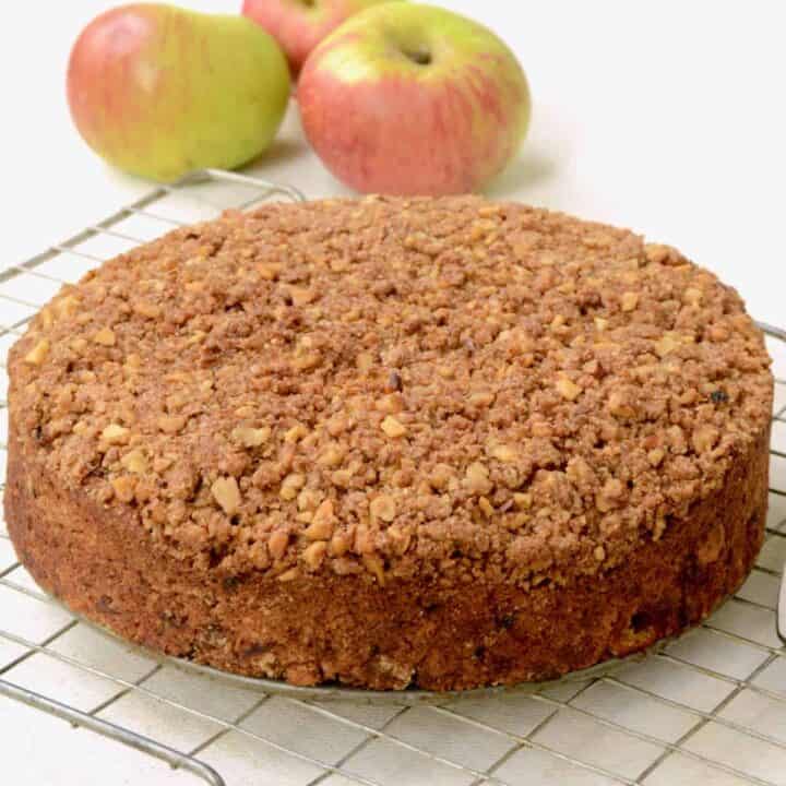 An apple cake covered in nut streusel on a wire rack.