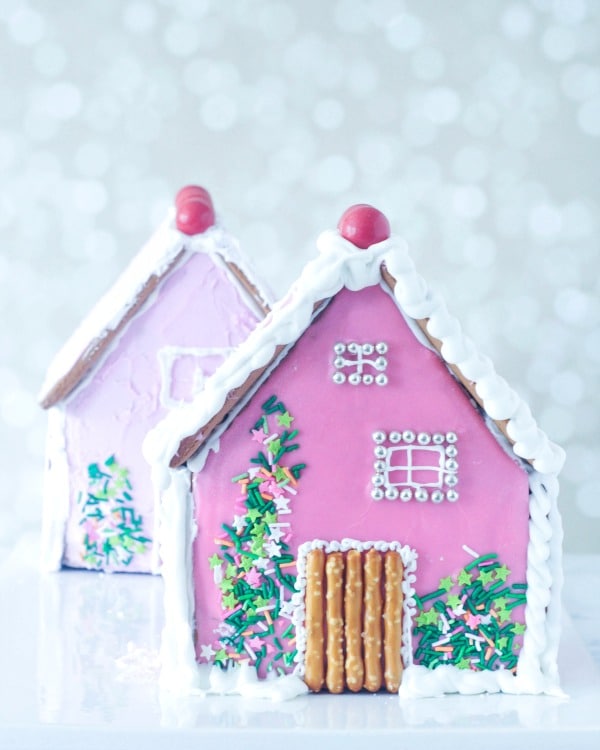 Two pink decorated gingerbread houses.