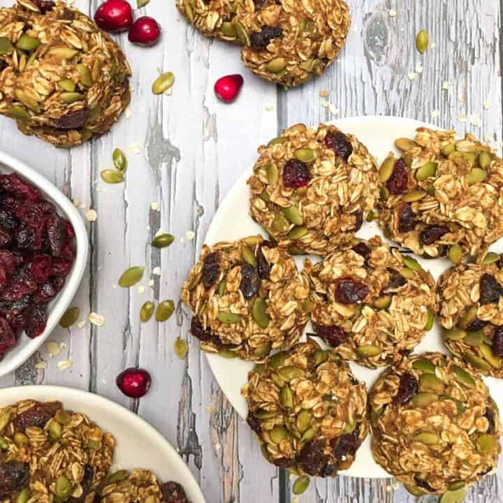 Cranberry and pumpkin seed oatmeal cookies on a plate.