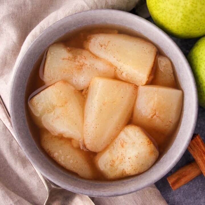 A bowl of cooked pear slices in their juice.