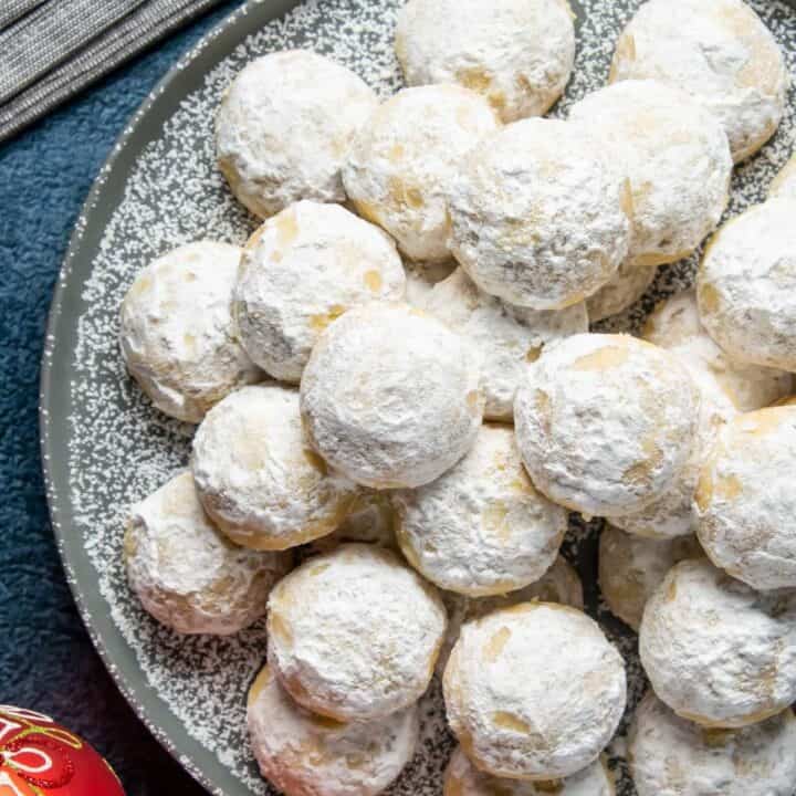 A pile of snowball cookies dusted in powdered sugar.