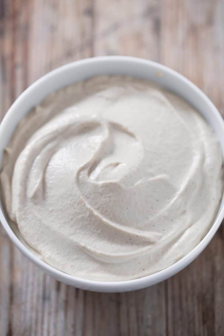 A bowl of thick and white cashew frosting.,