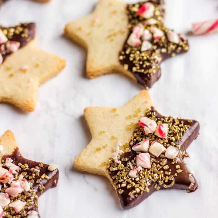 Star shaped shortbread cookies hipped in chocolate and coated in sugar and candy canes.