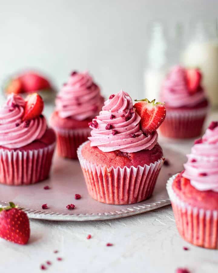 Pink cupcakes topped with swirls of strawberry frosting.