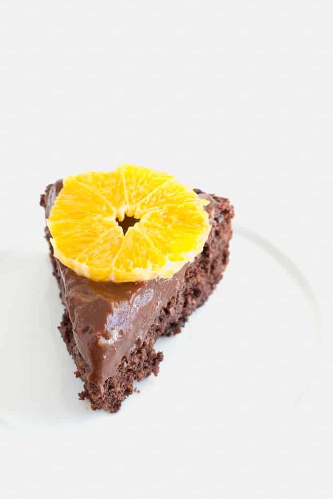 A slice of chocolate ckae topped with a piece of orange.