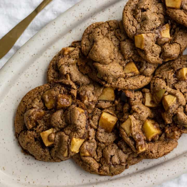 A pile of apple cookies on an oval platter.