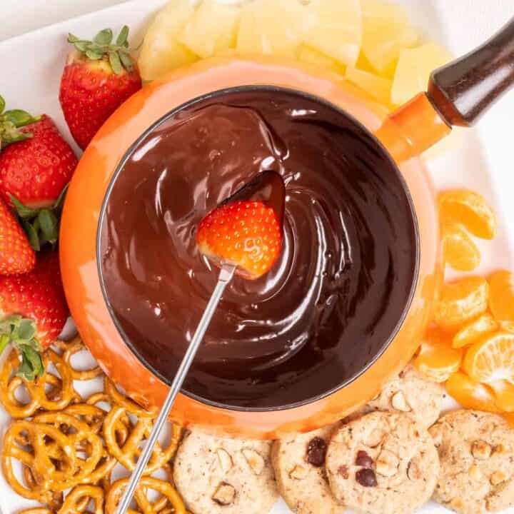 Dipping a strawberry into a chocolate fondue.