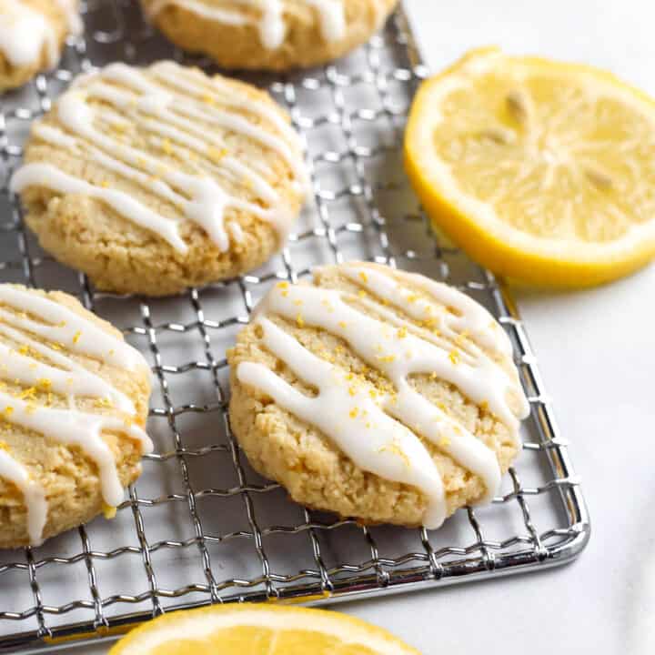 Cookies topepd with icing and lemon zest on a cooling rack.