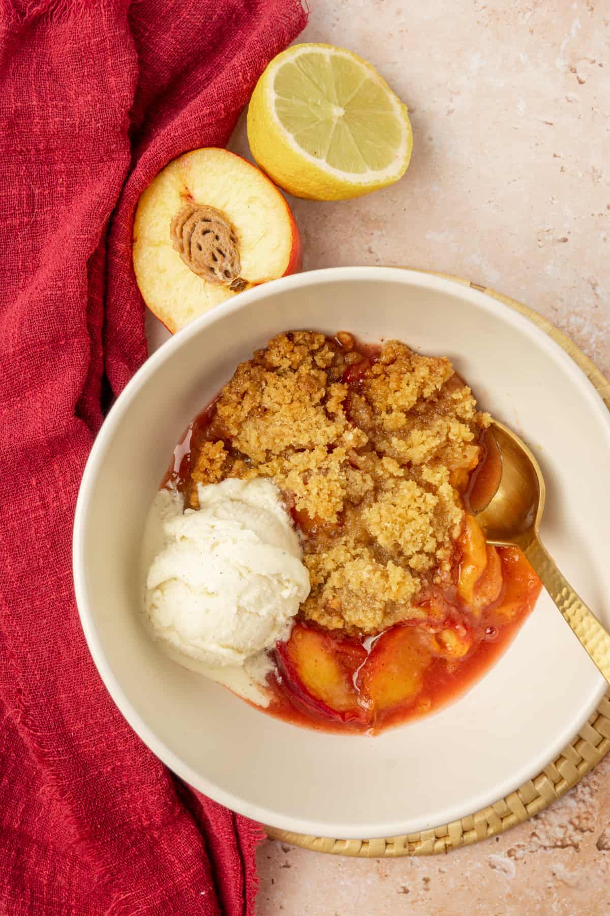Nectarine crumble topped with vegan vanilla ice cream in a bowl.