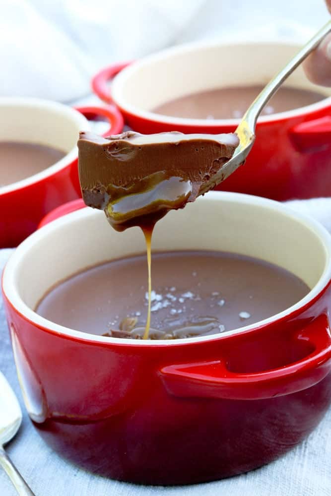 A spoon lifts a spoonful of chocolate and caramel dessert.
