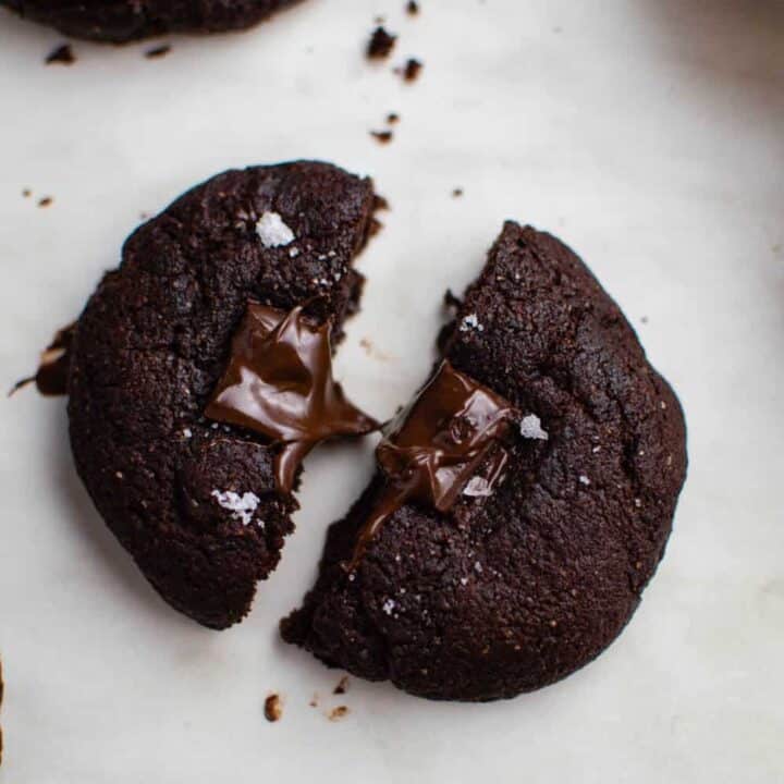 A dark chocolate cookie cut in half.