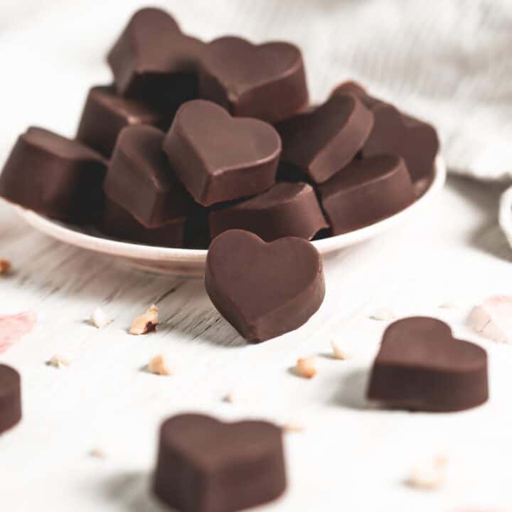 Heart shaped chocolates spilling from a small plate.
