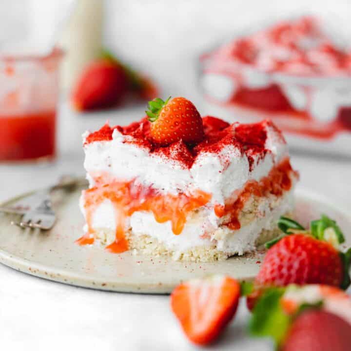 A layered dessert with cake, cream and strawberry layers.