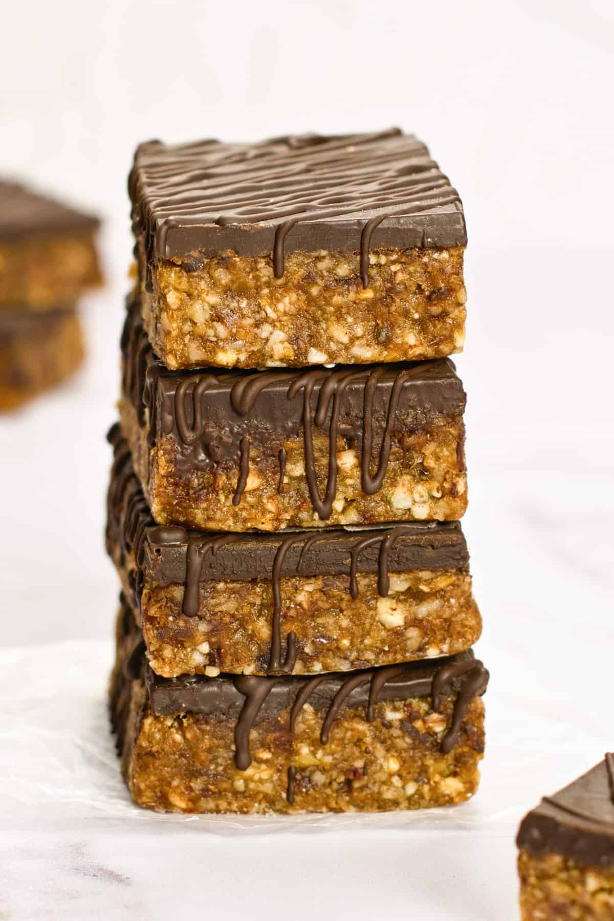 Four date, coconut and nut bars in a stack.
