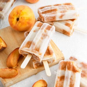 Vegan peach popsicles stacked in pairs.