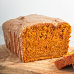 Vegan pumpkin bread that has been cut into revealing the crumb structure.