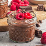 Coconut milk chocolate pudding topped with fresh raspberries and dark chocolate.